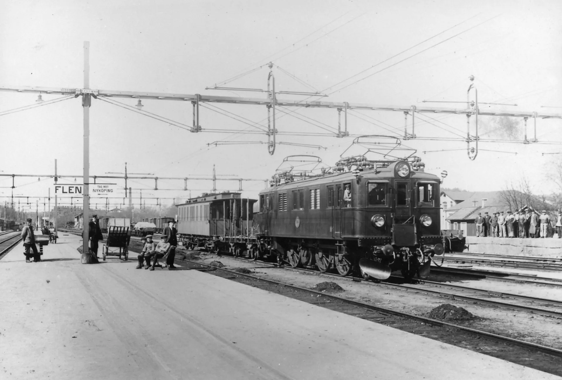 Provtåg med D 104 i Flen 1926. Närmst loket går en öppen vagn, för att personalen i den efterföljande inspektionsvagnens plattform ska kunna iaktta kontaktledning och strömavtagare.